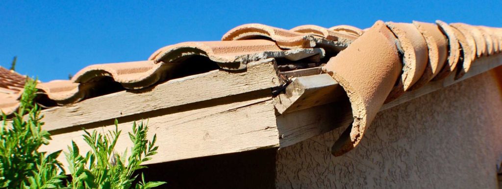 close-up of damaged concrete roof tile near the roofs rake. Roofing insurance claim tips