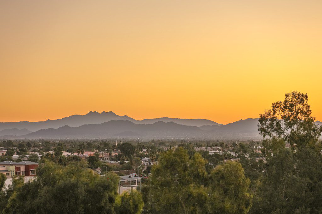 birds eye view of residential houses and their roofs overlooking a beautiful sunset in Mesa, Arizona suburbs of Phoenix