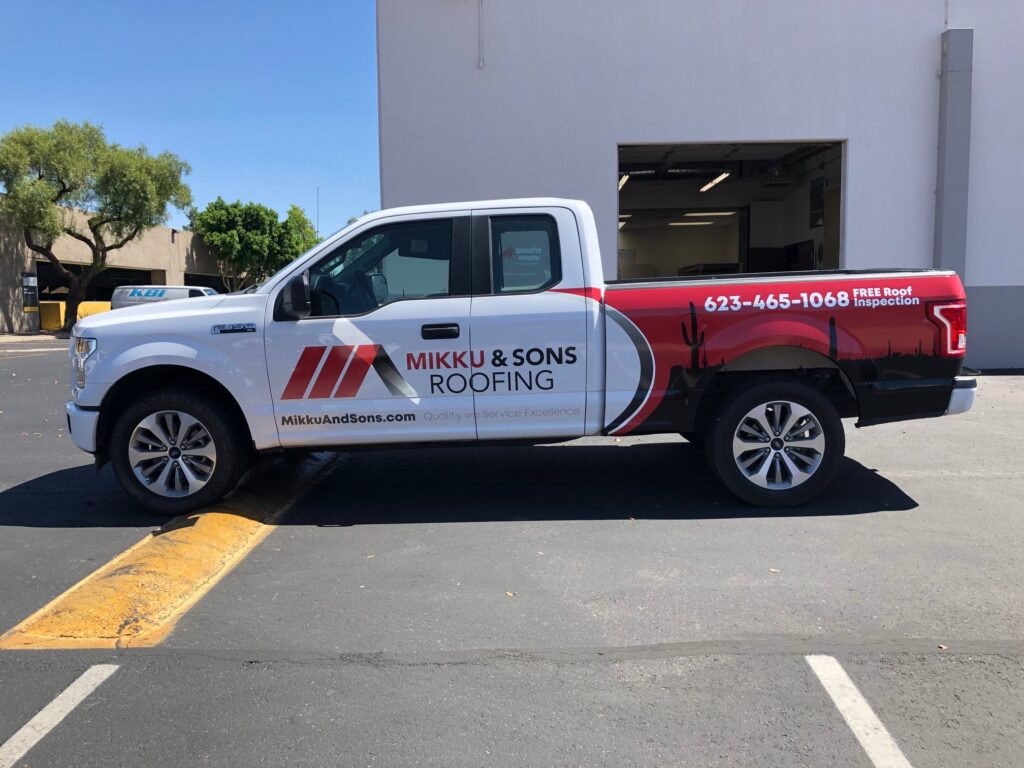 a white truck with a red and black stripe. Mikku and Sons Roofing Truck