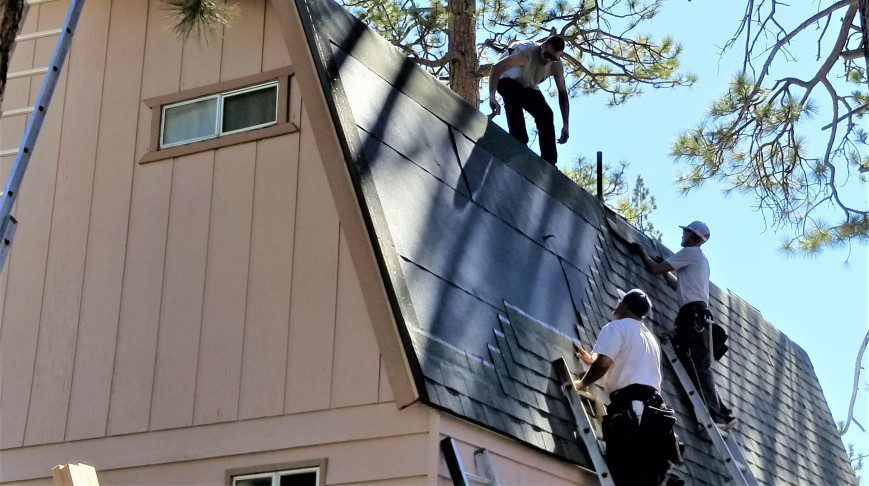 A trio of roofers laying new shingles