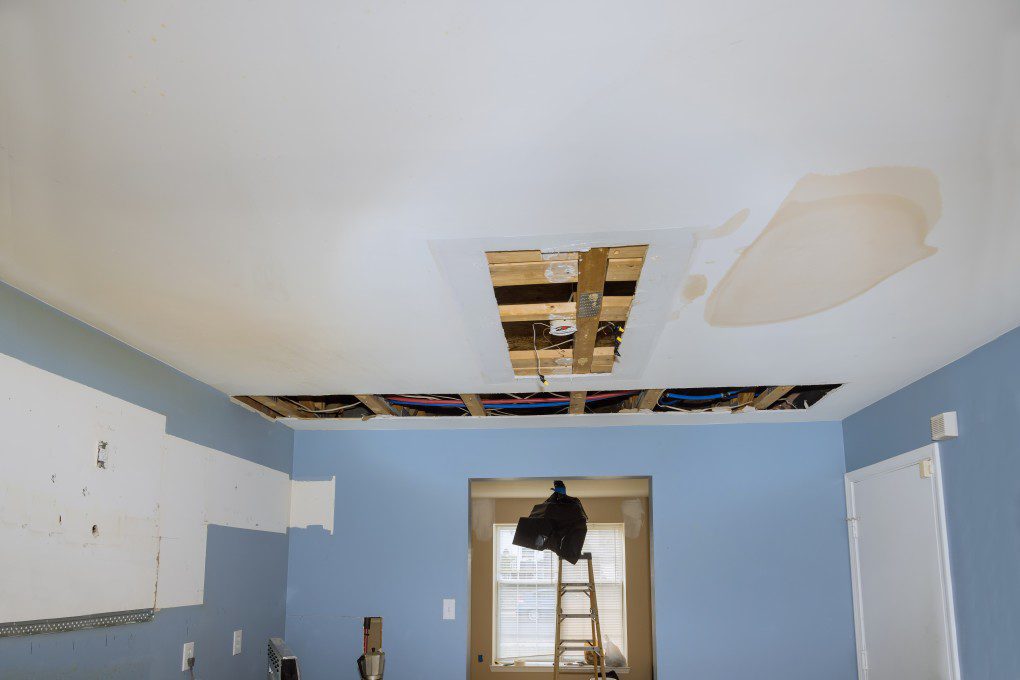 interior of a house with blue walls and a white ceiling with brown spots.