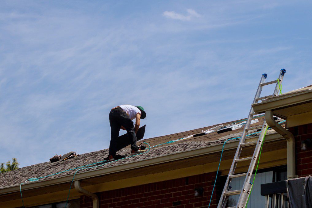 A roof repair worker walking on a roof 