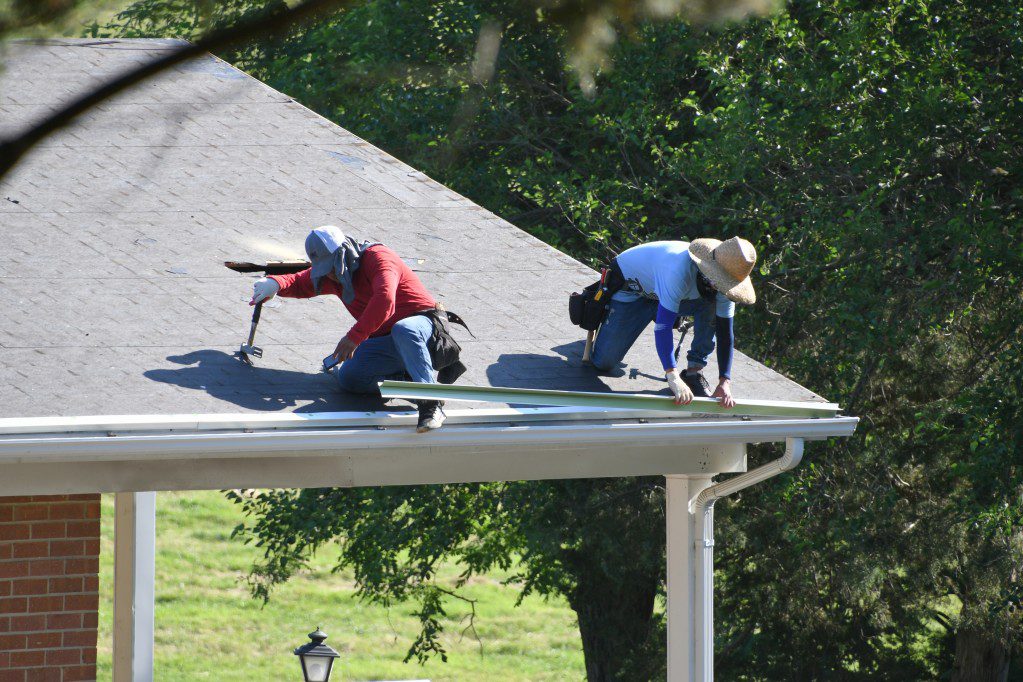 A roofing company making repairs to a damaged roof