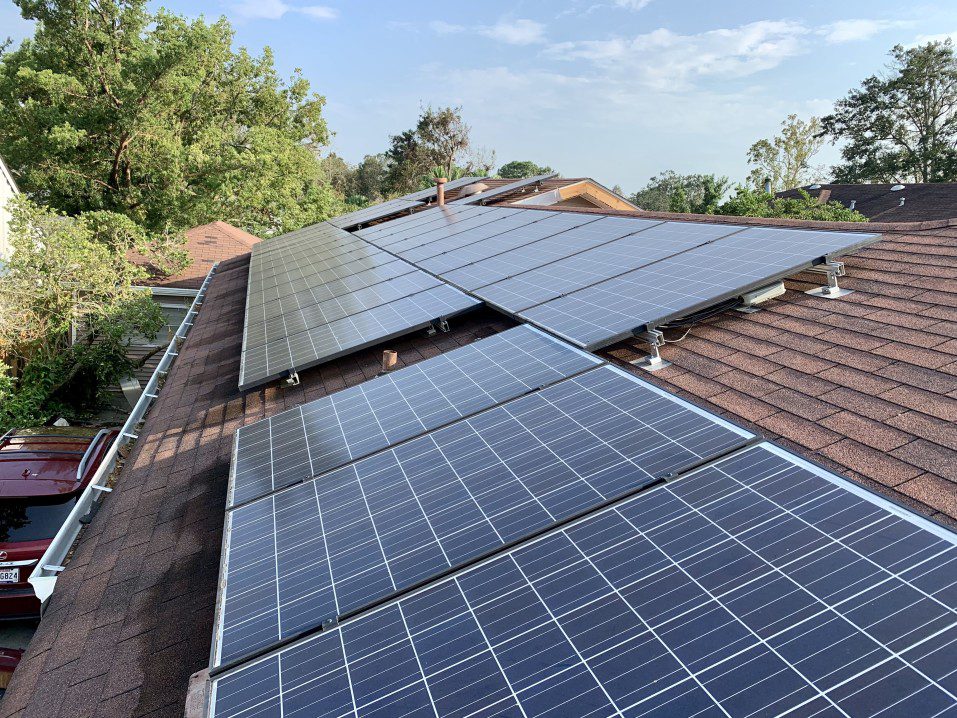 A row of solar panels on a shingled roof 