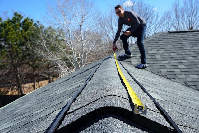 A mann measuring a roof 